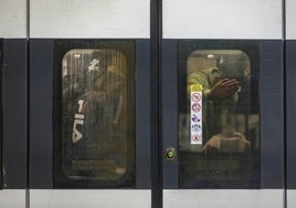 Usuarios de tren, dentro de un Cercanías en Valencia.