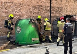 Los bomberos sofocan el fuego en los contenedores.