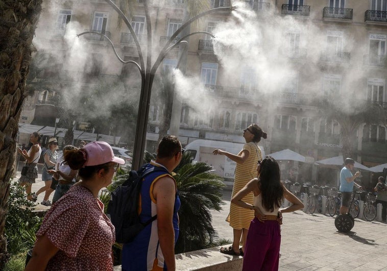 Un grupo de personas se refresca en Valencia.