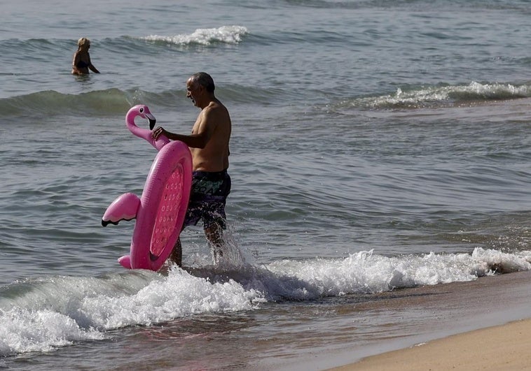 Un hombre se baña en la playa en Valencia, este domingo.