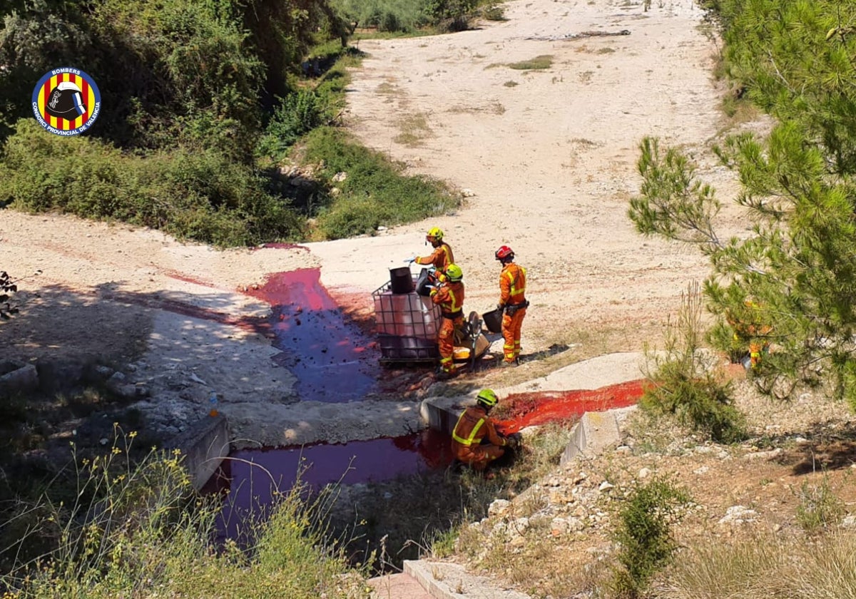 Los bomberos conteniendo el vertido en un barranco.