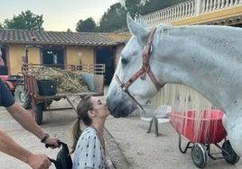 Carla Maronda, muy aficionada a la hípica, besa a su caballo Bolero desde su silla de ruedas.