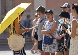 Unos turistas se protegen del calor en Valencia.