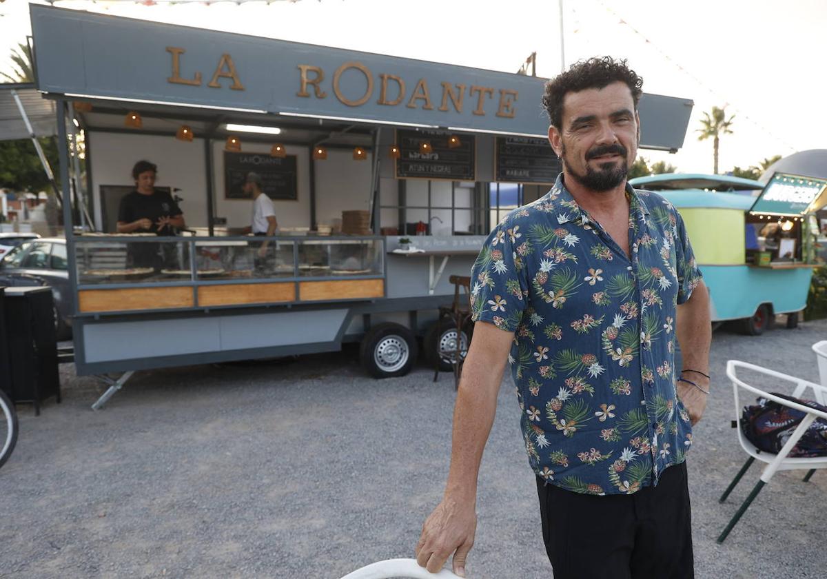 Juan Carlos del Toro, en Pampa Beach, en Canet, con dos de los 'food trucks' que gestiona.