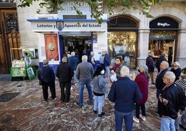 Varios jugadores esperan para comprar boletos de Lotería Nacional en una administración.