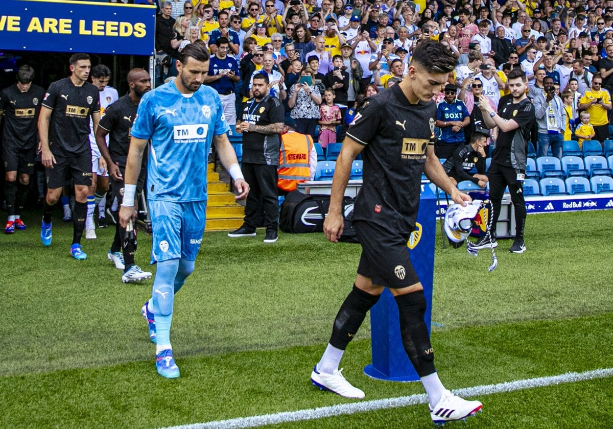 Pepelu y Dimitrievski, con gestos serios, encabezan la salida del Valencia al campo.