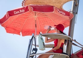 Una socorrista de Cruz Roja se refresca en una torre de vigilancia de la playa.