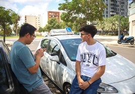 Dos jóvenes esperan a la examinadora para hacer su examen de conducir.