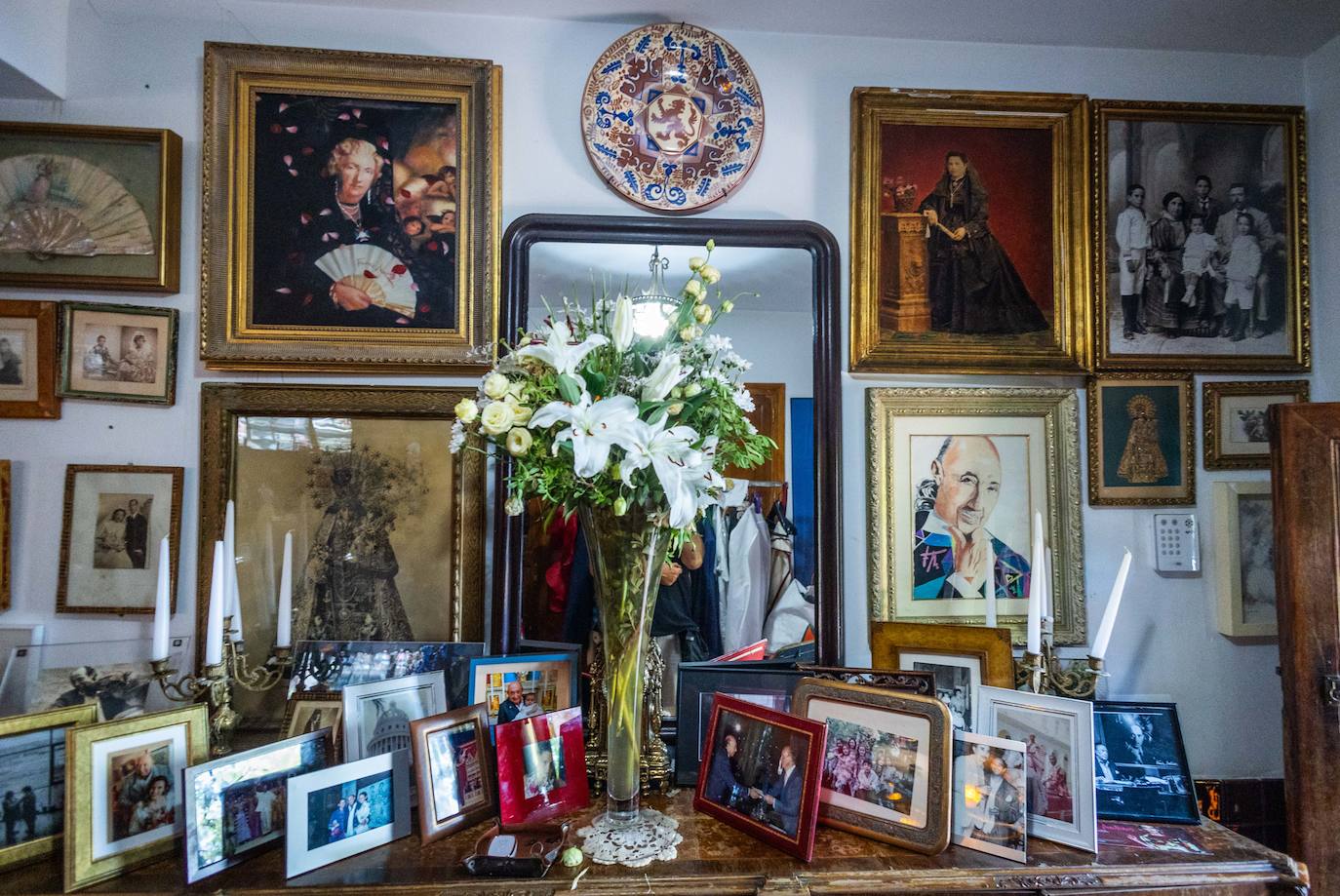 Un ramo de gladiolos, rosas y margaritas da vida a la entrada a la casa, un rincón lleno de fotografías, donde la familia y la Virgen tienen un lugar privilegiado.