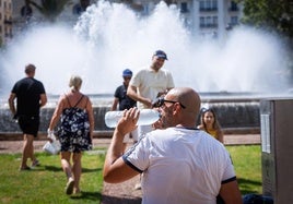 Un hombre bebe agua para refrescarse, este viernes, en el centro de Valencia.