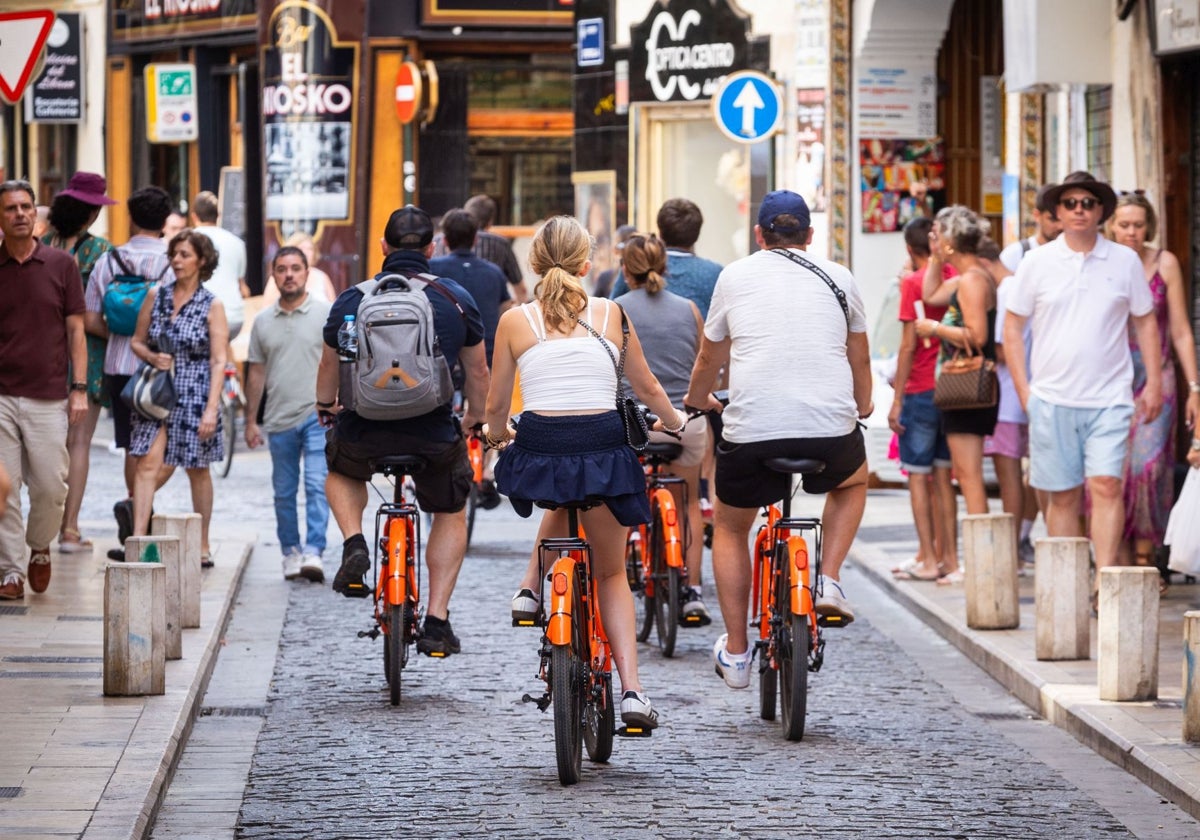 Turistas en bicicleta por las calles del centro histórico de Valencia.