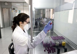 Una técnico de laboratorio analiza aguas residuales en busca de virus.