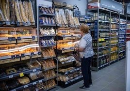 Una cliente compra el pan en un supermercado.