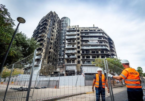 Operarios instalan el vallado alrededor del edificio.