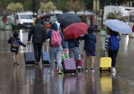 Un grupo de turistas se protege de la lluvia con paraguas.