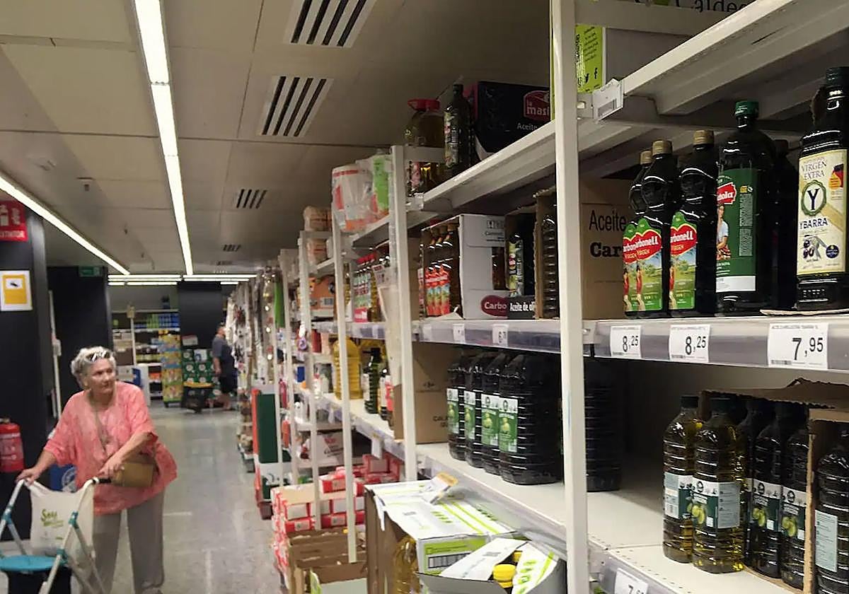 Lineal de un supermercado con diversas botellas de aceite de oliva.