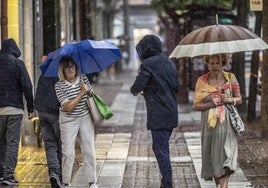 Varias personas se protegen de una tormenta de verano, en una imagen de archivo.