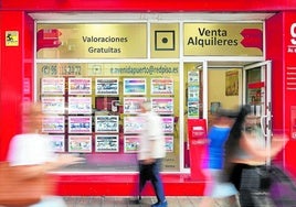 Varias personas caminan junto a la puerta de una inmobiliaria de Valencia, en una imagen de archivo.