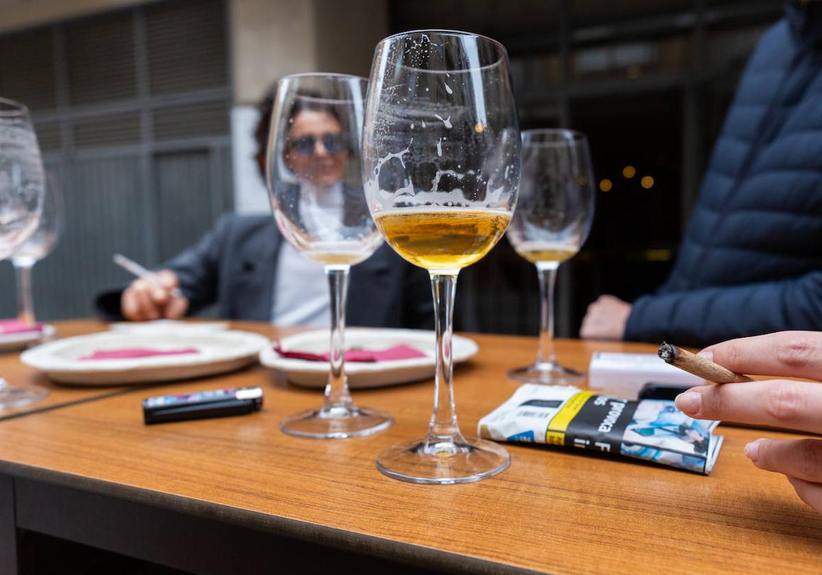 Una mujer fumando en un bar.