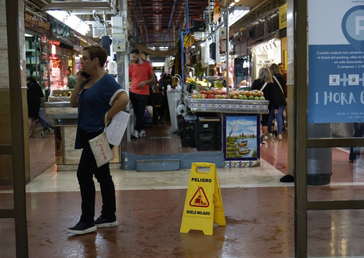 Imagen secundaria 1 - Vendedores y operario municipal, retirando el agua en el mercado del Cabanyal.