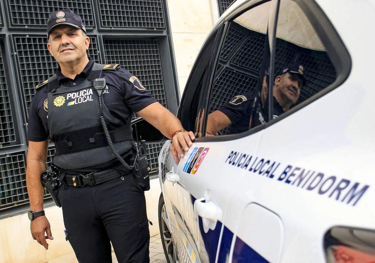 El agente Luisma Roselló, junto a un coche patrulla.