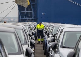 Un operario revisa los vehículos en el interior de un buque de transporte.