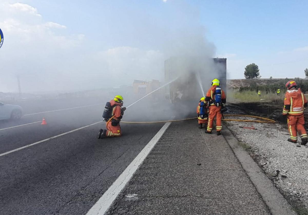 Bomberos apagando las llamas del camión.