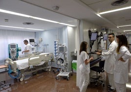 Varios médicos y sanitarios en una sala de un hospital.