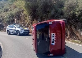 El coche volcado en medio de la calzada.