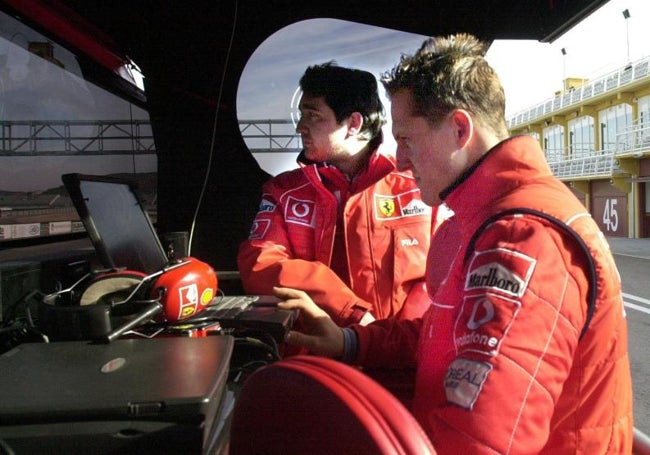 Schumacher consulta tiempos en el muro de Ferrari en el pit lane dde Cheste.