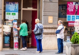 Varios mayores hacen cola en una agencia de viajes.