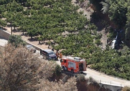 Equipos de bomberos, junto al helicóptero siniestrado.