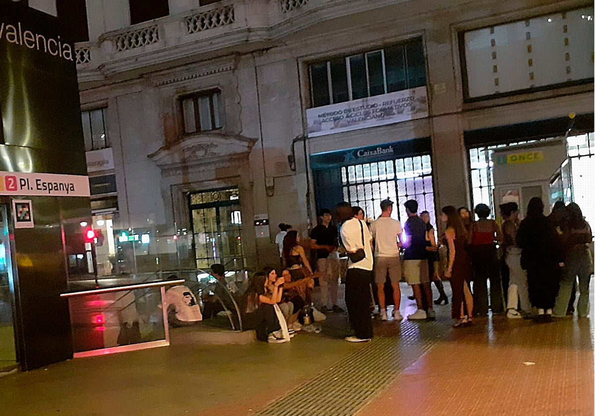 Un grupo de chavales bebe en la entrada al metro de Plaza de España.