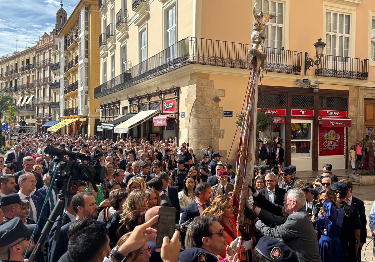 Momento del cambio de manos de la Señera, con Catalá, de naranja, ya como portadora.