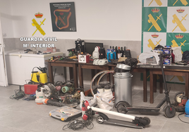 Un guardia civil junto a las herramientas, armas y aparatos intervenidos a los ladrones.