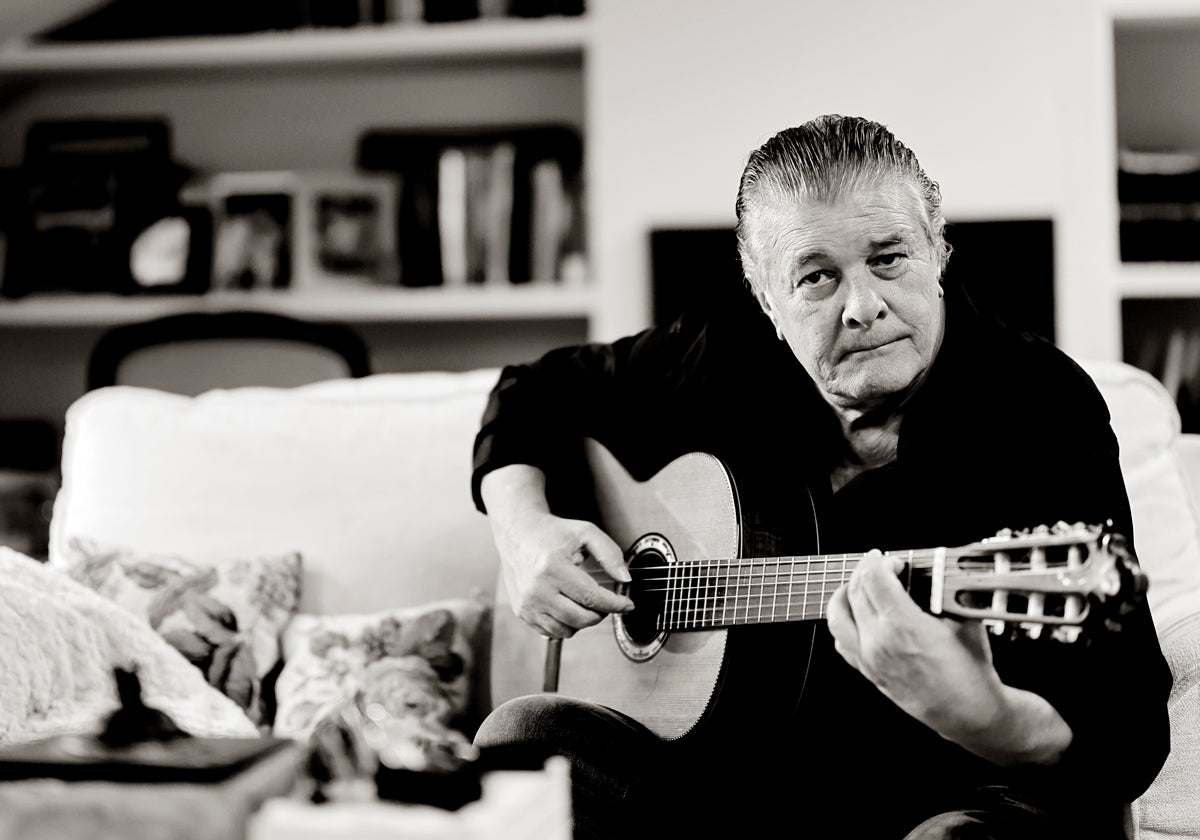 Francisco toca la guitarra en el salón de su casa en Godella.