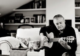 Francisco toca la guitarra en el salón de su casa en Godella.