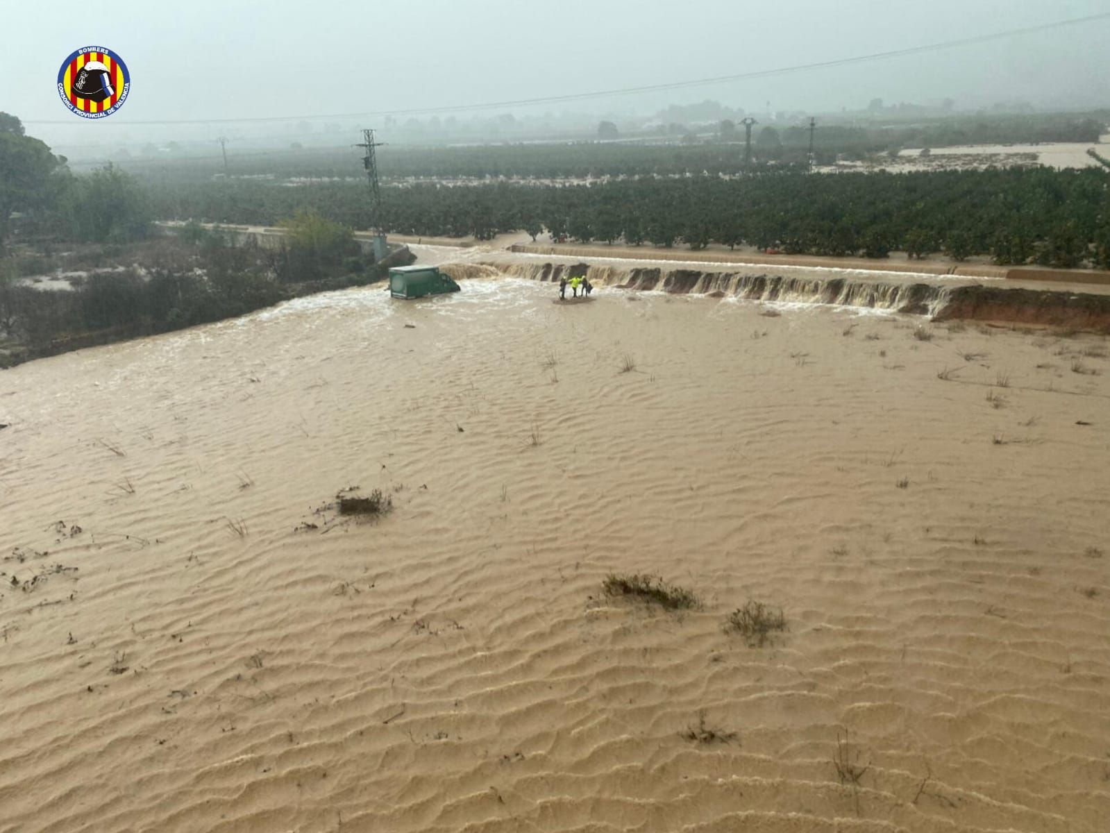 FOTOS | Los bomberos rescatan a un camionero arrastrado por el agua en Alzira