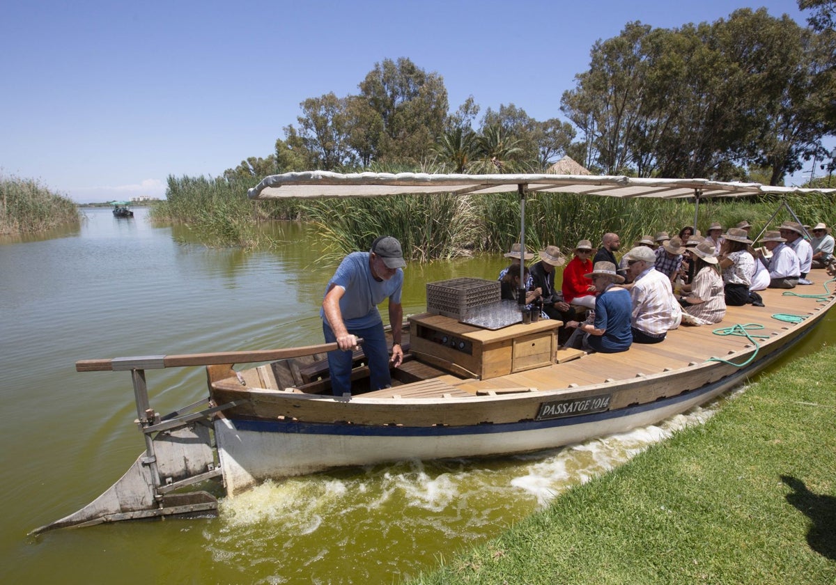 Lago de la Albufera de Valencia, con turistas realizando un recorrido en barca.