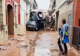 Una calle de Paiporta taponada por varios coches arrastrados por el agua.