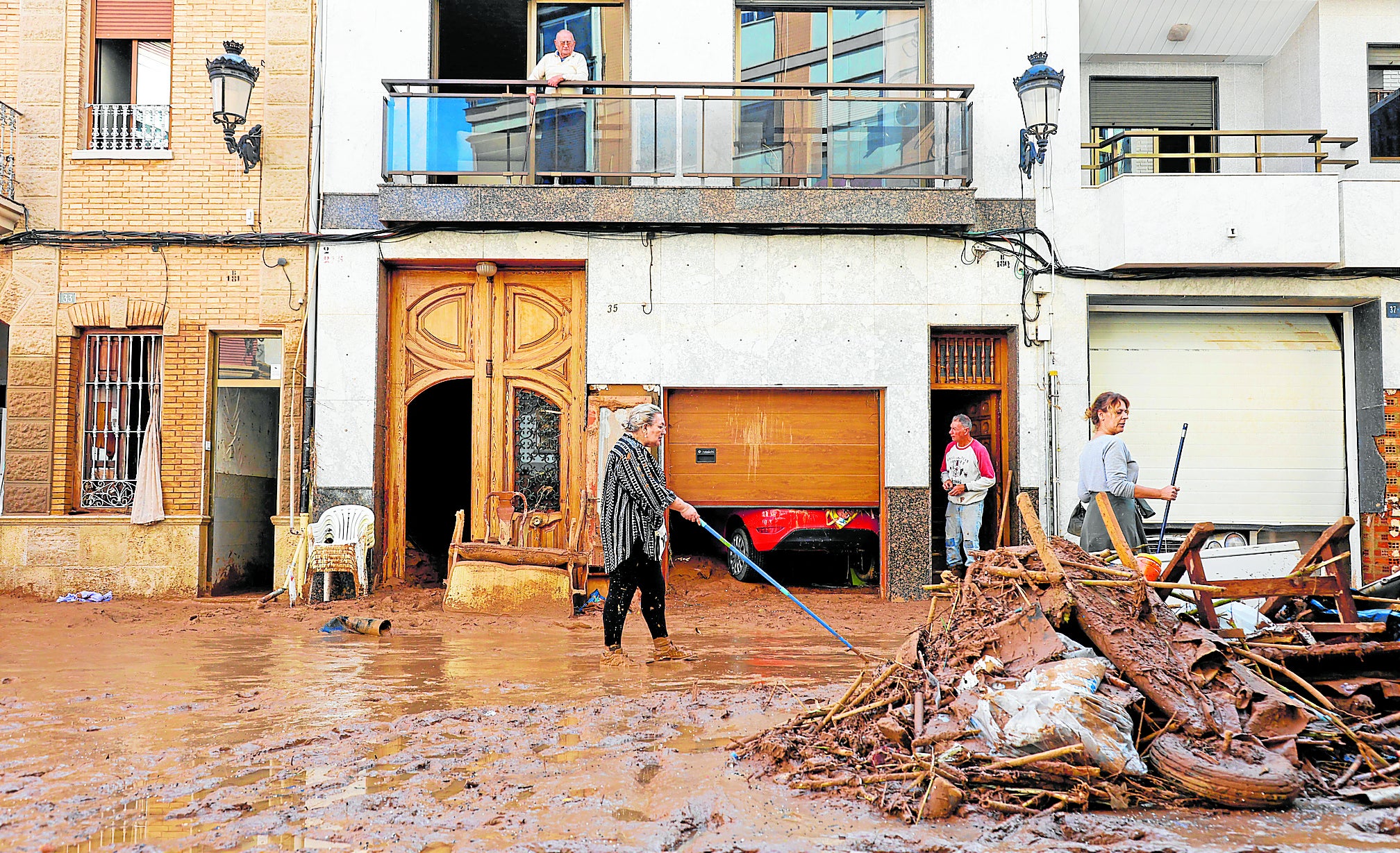 Varias personas limpian una calle de Paiporta, este jueves.