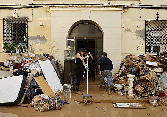 Vecinos de La Torre intentan limpiar el interior de sus viviendas, este viernes.
