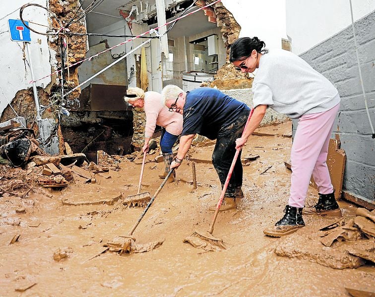 Tres mujeres ayudan en la calle.