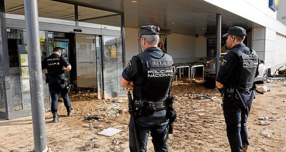 Policías nacionales vigilan los accesos al centro comercial MN4 en Alfafar.