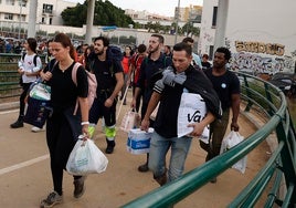 Personas se dirigen con víveres y productos de primera necesidad hacia La Torre desde la pasarela que comienza en San Marcelino.