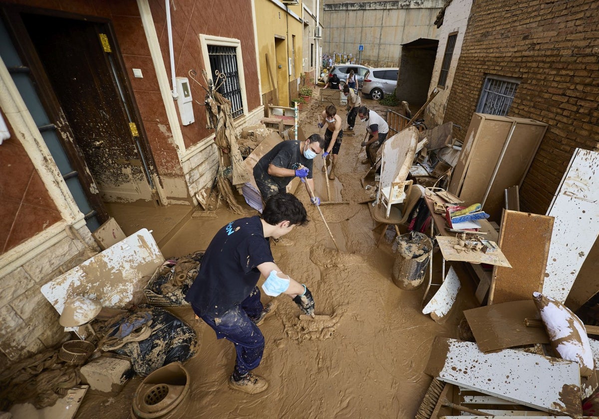 Los vecinos achican agua en una calle de Horno de Alcedo.