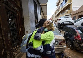 Dos amigas se abrazan en medio de la destrucción.