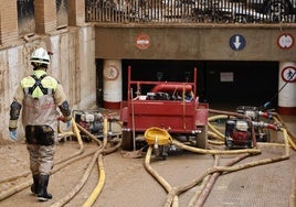 Un bombero de la Diputación de Zaragoza comprueba las bombas que achican agua del parking subterráneo de la plaza Mayor de Catarroja.