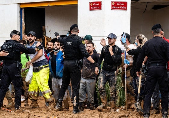 Vecinos indignados contenidos por las fuerzas de seguridad justo antes de que llegasen las autoridades.