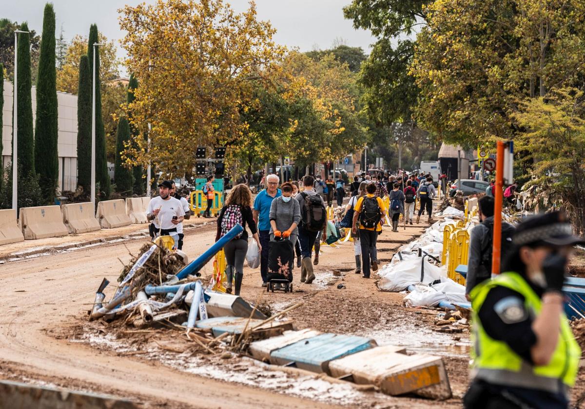 Ciudadanos en Picanya, a pie, en el único puente que no se derrumbó tras el paso de la DANA.